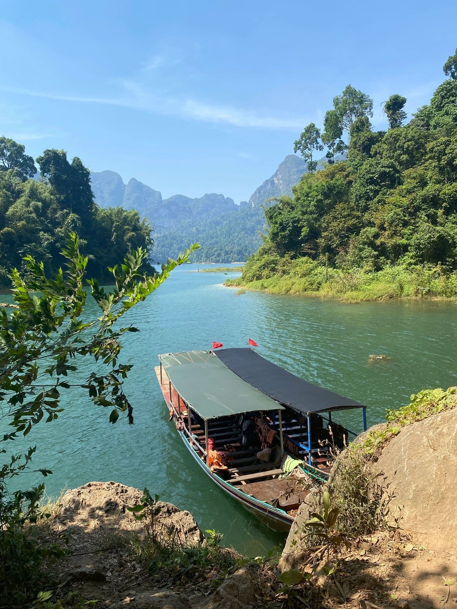 Long-tail boat on turquoise water at Khao Sok, Thailand