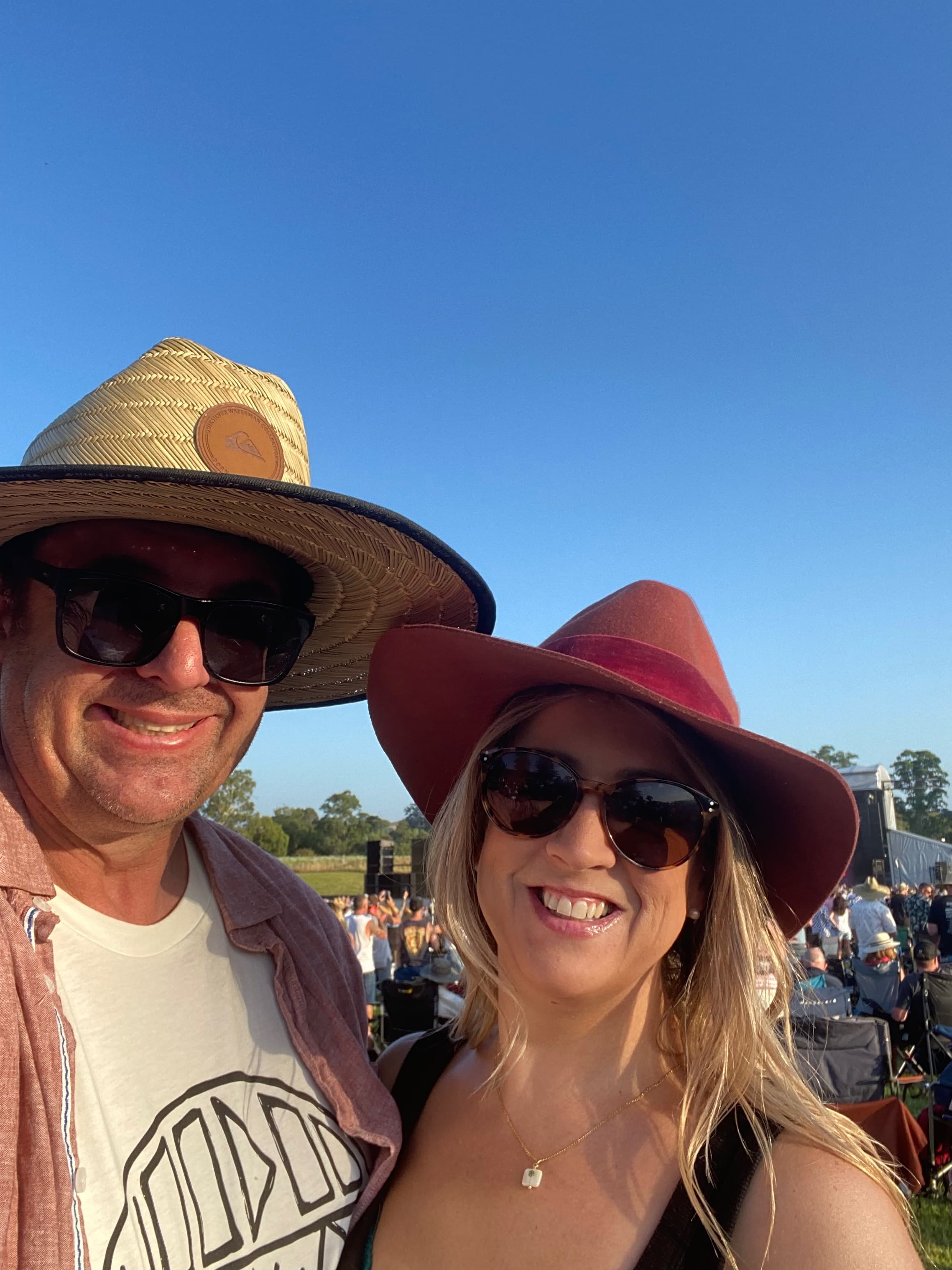 Gary and Cindy smiling at an outdoor festival in a grassy field